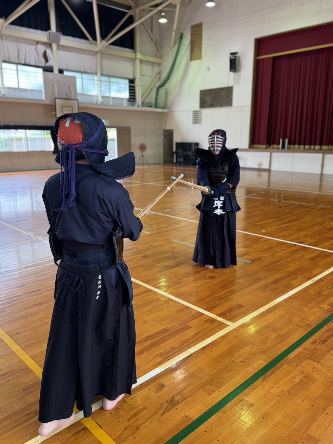 Two kendo practitioners facing off in kamae during practice