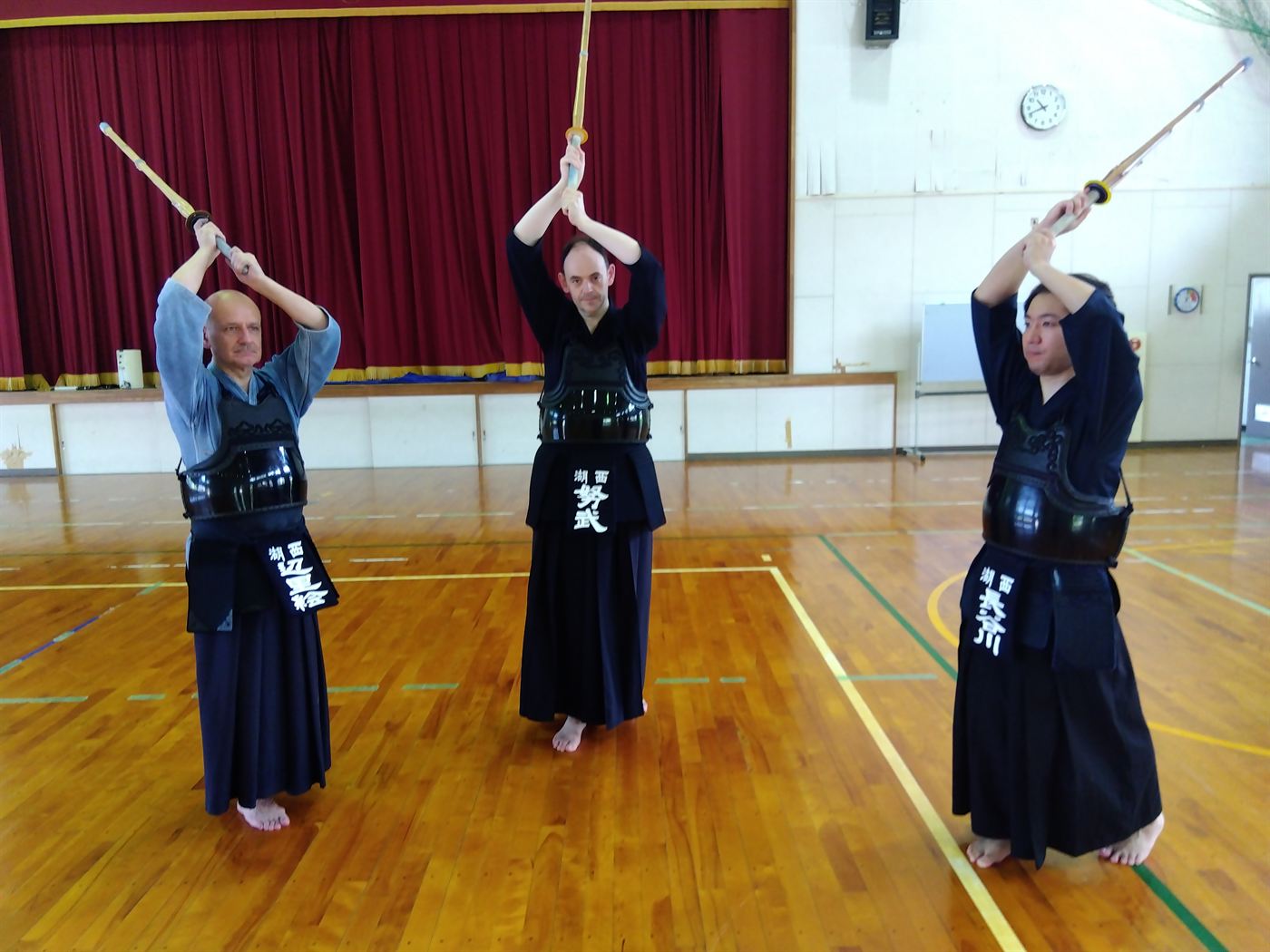 Kendo practitioners raising their shinai during suburi practice